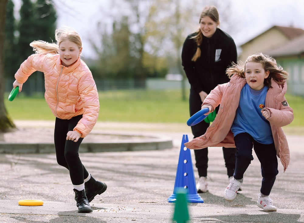 Kinder bei einem Bewegungsspiel in der Ferienbetreuung