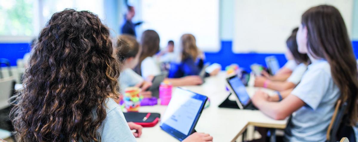 Schülerinnen und Schüler arbeiten im Unterricht mit Tablets