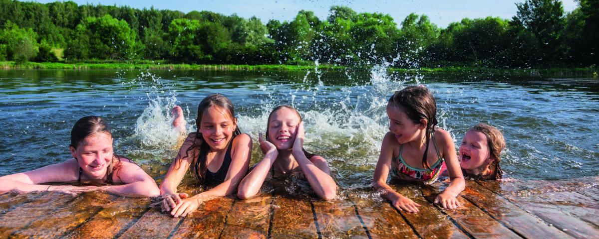Kinder schwimmen gemeinsam in einem See