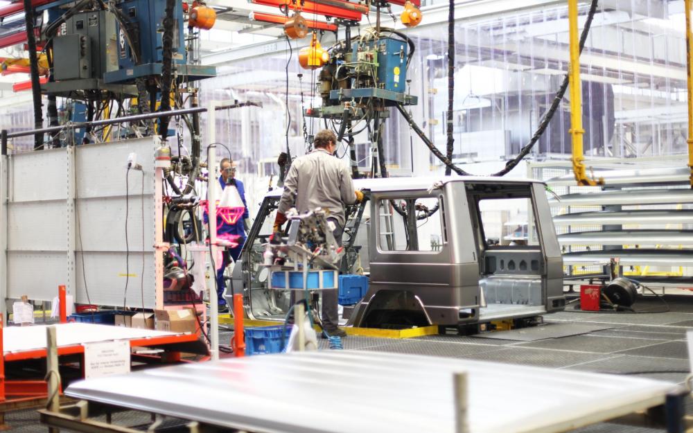 Automobilproduktion in Baden-Württemberg. Fließband, ein Mann checkt eine Karosserie