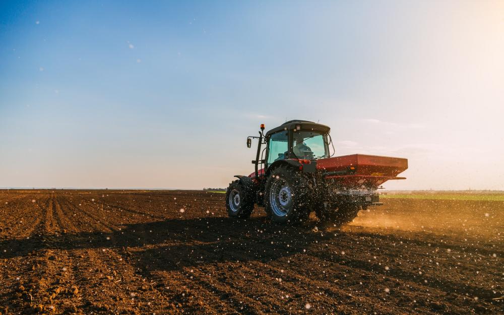 Traktor bringt Dünger auf einem Feld aus