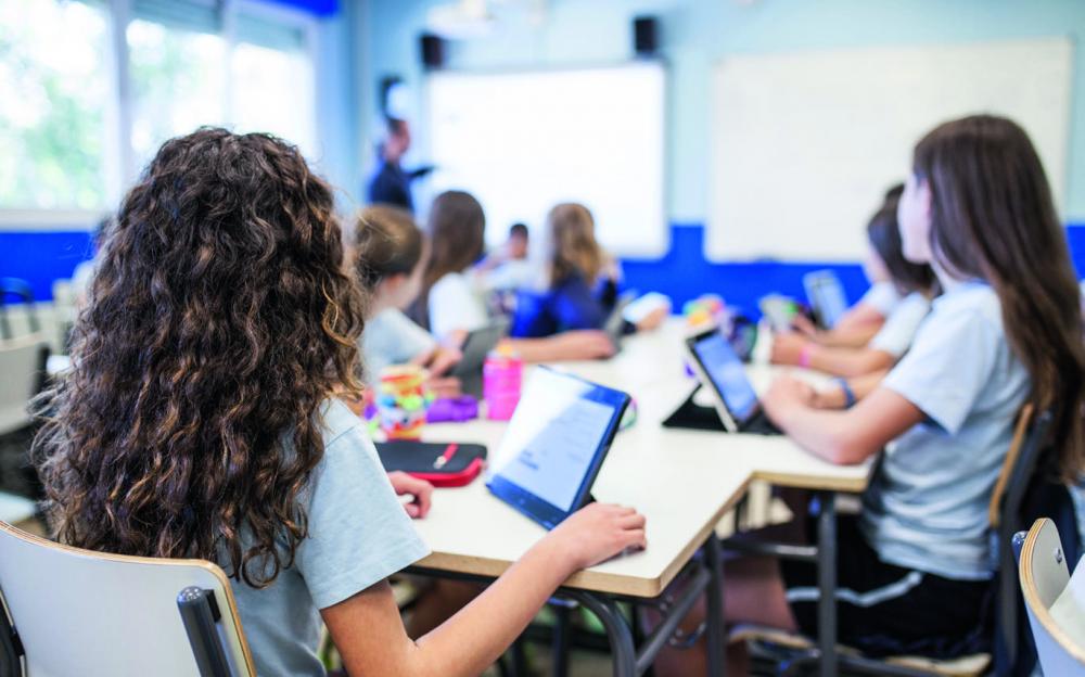 Schülerinnen und Schüler arbeiten im Unterricht mit Tablets