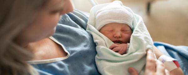 Mutter nach der Geburt mit neugeborenem im Arm