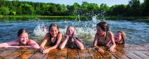 Kinder schwimmen gemeinsam in einem See